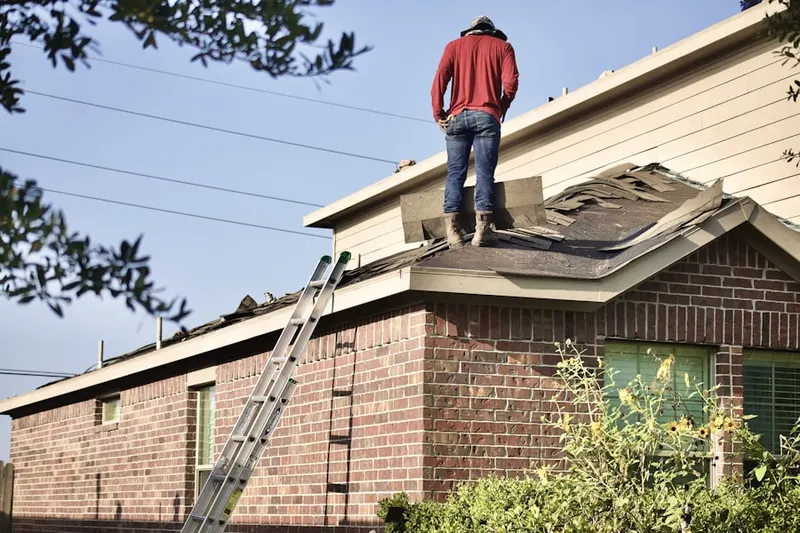 Professional roofer working on a residential roof in Bondsville